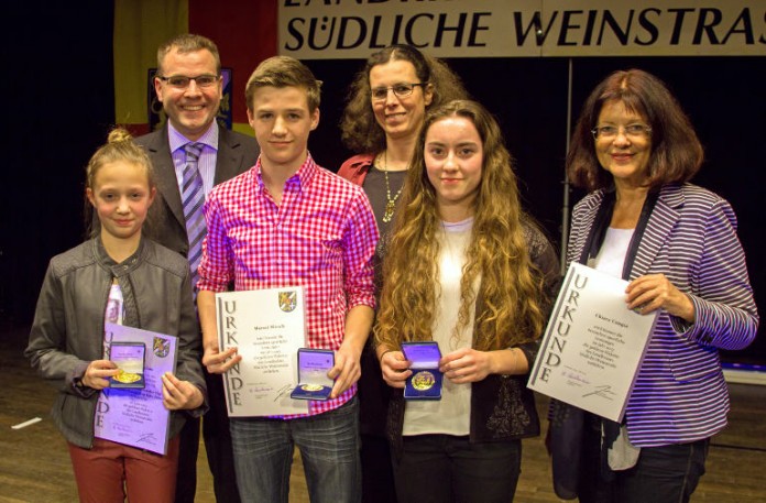 Landrätin Theresia Riedmaier (rechts) und Erster Kreisbeigeordneter Nicolai Schenk (2. v.l.) überreichen Fabienne Janetzki, Marcel Münch, Trainerin Alexandra Diettrich und Chiara Congia (v.l.n.r.). die Auszeichnung „Gold“.